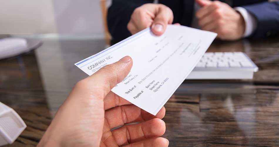 Man receiving a check and wondering how long it will take to clear