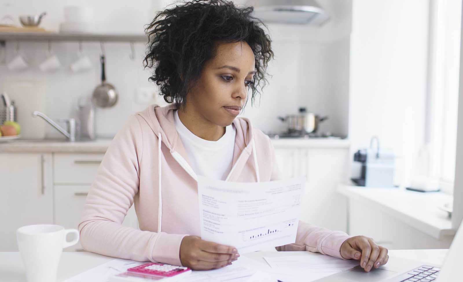 Woman reading her mortgage statement and researching what it means online
