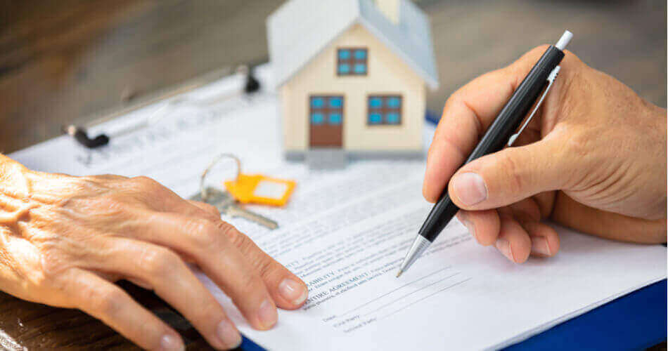One hand with pen about to sign documents to show how to get equity out of your home
