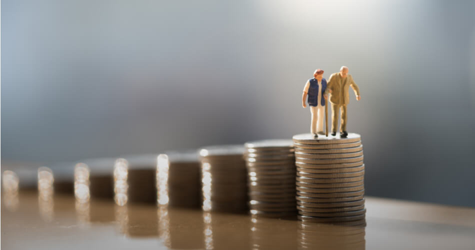 Increasingly tall stacks of coins with figures of an elderly couple standing on top of the tallest stack